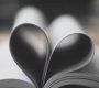 Open book pages forming a heart shape, symbolizing love and creativity.
