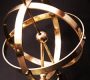 Close-up of a brass armillary sphere on a marble base, highlighting intricate metalwork and design.
